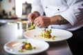 chef garnishing plates with herbs at plating area