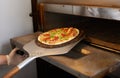 Chef gets ready pizza out of oven