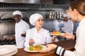 Chef giving out ready salads to waitress