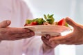 Chef giving salad in plate to waiter at kitchen restaurant Royalty Free Stock Photo