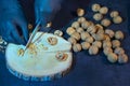 Chef in gloves chops walnuts with a knife on a wooden board