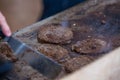 Chef grilling appetising beef burgers outdoors on open kitchen at music festival event