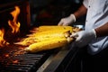 chef grilling corn on the cob in a restaurant