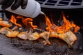 Chef grilling fresh red king prawns on brazier with hot flame - close up