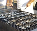 Chef grilling young sardines