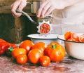 Chef grinds pieces of ripe tomatoes in an old vintage manual grinder to make homemade sauce, ketchup Royalty Free Stock Photo