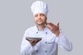 Chef Guy Holding Plate Smelling Dish Posing Over Gray Background