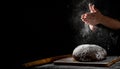 Chef hand clap with splash of white flour and black background with copy space. woman`s hands Making bread Royalty Free Stock Photo