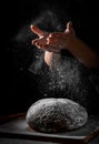 Chef hand clap with splash of white flour and black background with copy space. woman`s hands Making bread Royalty Free Stock Photo