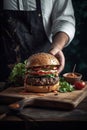 Chef hand holding a platter with delicious burger