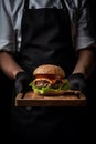 Chef hand holding a platter with delicious burger