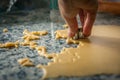 A hand making shapes in an extended dough on a kitchen table making seasonal pastry food.