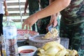 Chef hand, male soldier Is using a knife to cut chicken meat on a wooden chopping board, Thai food