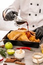 Chef hands cooking duck with oranges and apples on white kitchen background. add soy sauce. Food concept