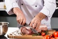 Chef hands cut beef at kitchen restaurant. Closeup chef hands cutting beef.