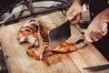 Chef Hands cutting grilled rabbit for steaks with knife on cutting board. Hot Meat dishes. Royalty Free Stock Photo