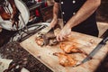 Chef Hands cutting grilled rabbit for steaks with knife on cutting board. Hot Meat dishes