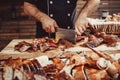 Chef Hands cutting whole grilled lamb for steaks with knife on cutting board. Hot Meat dishes