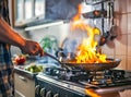 Chef hands keep wok with fire. Closeup chef hands cook food with fire. Chef man burn food at professional kitchen. Royalty Free Stock Photo