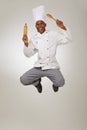 This chef is a high roller. A African-American chef jumping in the air holding a roller and a spoon.