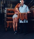 A chef and his female helper in a sausage storage.