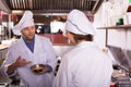 Chef and his helper at bistro kitchen Royalty Free Stock Photo