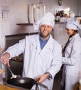 Chef and his helper at bistro kitchen Royalty Free Stock Photo