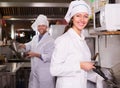 Chef and his helper at bistro kitchen Royalty Free Stock Photo