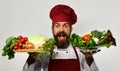 Chef hold board with fresh vegetables on board and bowl