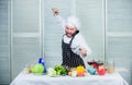 Chef hold cleaver knife tool ready to chop ingredients. Man wear apron cooking in kitchen. Man use sharp cleaver knife Royalty Free Stock Photo