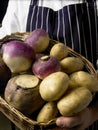 Chef holding a basket of root vegetables