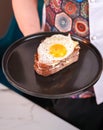 Chef Holding Croque Madame Sandwich with Fried Egg and Gouda on Multigrain Bread Royalty Free Stock Photo