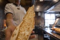 Chef holding freshly baked Turkish cheese pide at restaurant