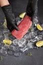 Chef holding piece of Fresh cooled tuna Fish fillet over pieces of ice