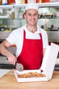 Chef holding pizza cuter, ready to cut. Royalty Free Stock Photo