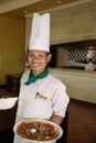 Chef holding pizza at restaurant