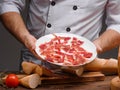 Chef is holding a plate with thinly sliced jamon Royalty Free Stock Photo