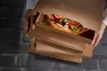 Chef holding a stack of cardboard pizza boxes