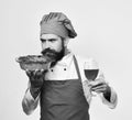 Chef holds bowl with potato casserole and glass of alcohol