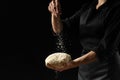 The chef holds the dough for bread, Italian pizza, focaccia. Freezing the flour in the air. Bakery, baking, cooking concept. On a