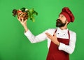 Chef holds lettuce, tomato, pepper and mushrooms up.