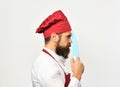 Chef holds sharp blue knife, side view. Man with beard