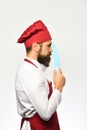 Chef holds sharp blue knife, side view. Man with beard