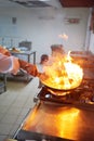 Chef in hotel kitchen prepare food with fire Royalty Free Stock Photo