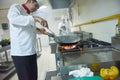 Chef in hotel kitchen prepare food with fire Royalty Free Stock Photo