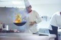 Chef in hotel kitchen prepare food with fire Royalty Free Stock Photo