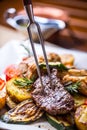 Chef in hotel or restaurant kitchen cooking only hands. Prepared beef steak with vegetable decoration Royalty Free Stock Photo