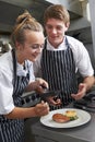 Chef Instructing Trainee In Restaurant Kitchen Royalty Free Stock Photo