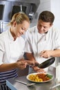 Chef Instructing Trainee In Restaurant Kitchen Royalty Free Stock Photo