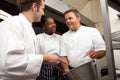Chef Instructing Trainees In Restaurant Kitchen Royalty Free Stock Photo